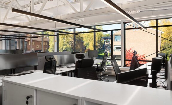 Kontorlandskap med store vinduer ut mot nabolag